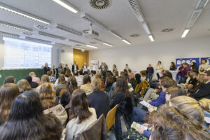 Ein Gesamtüberblick auf den Veranstaltungsraum mit Unternehmen und Teilnehmenden.