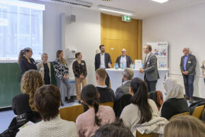 Unternehmensvertreter an Stehtischen im Gespräch mit den Teilnehmenden